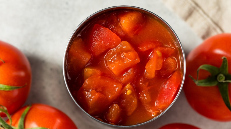 A top-down close-up of an open can of tomatoes