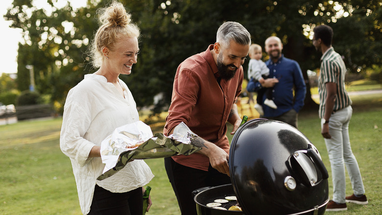 Happy couple enjoying a barbecue with friends