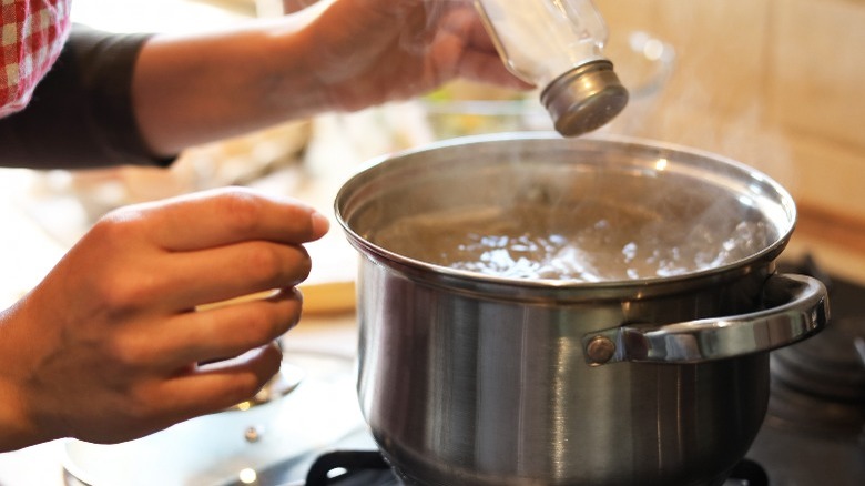 shaking salt into boiling water