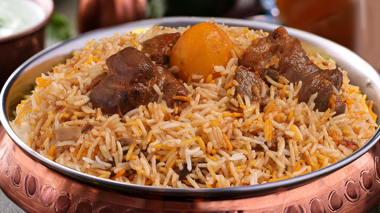 Close up of biryani served in a bronze dish