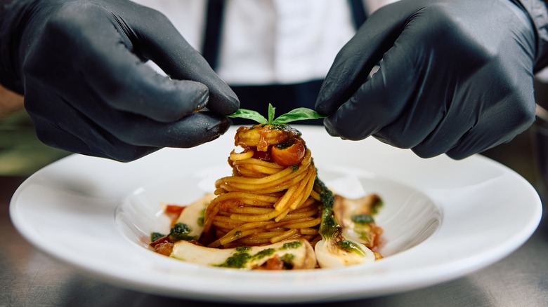 Close up of professional chef serving pasta