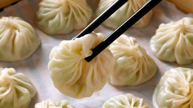 A close-up chopsticks holding of xiao long bao