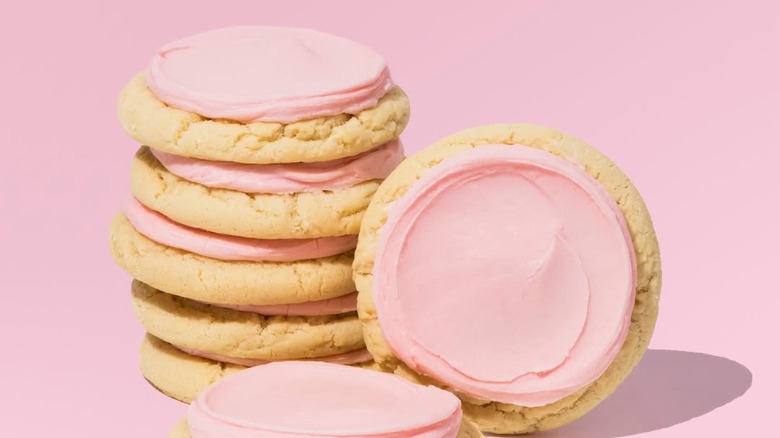 Stack of Crumbl Pink Sugar cookie on pink background