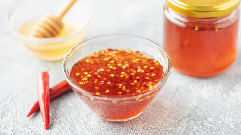 hot honey in a bowl with chili peppers in background
