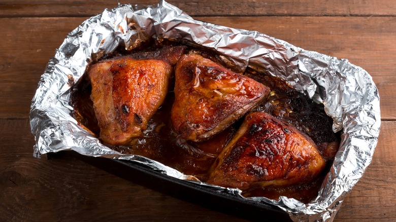 Baked chicken thighs in spices and crispy sauce in foil