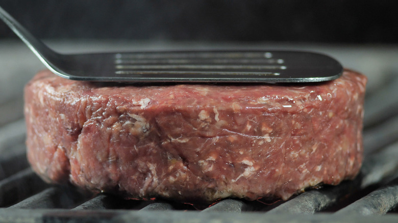 pressing on burger with spatula