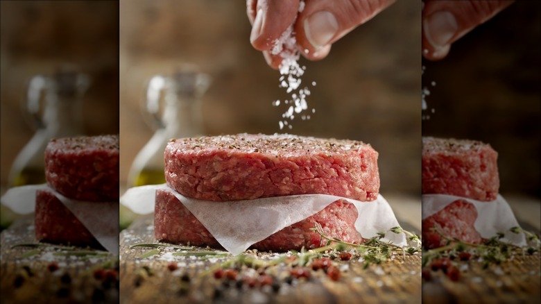 sprinkling salt on a hamburger