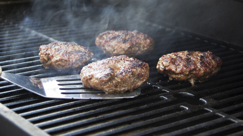 flipping burgers on grill