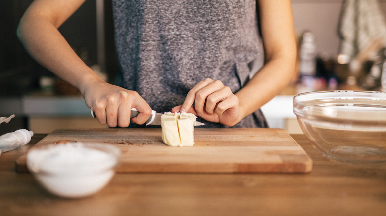person cutting butter