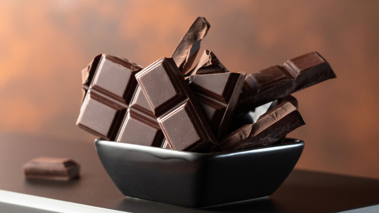 Broken dark chocolate bar in small black dish