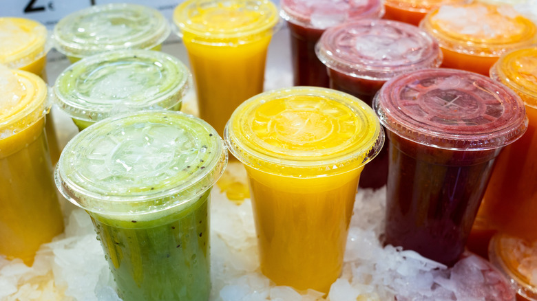 Summer fruit smoothies in cups with straws