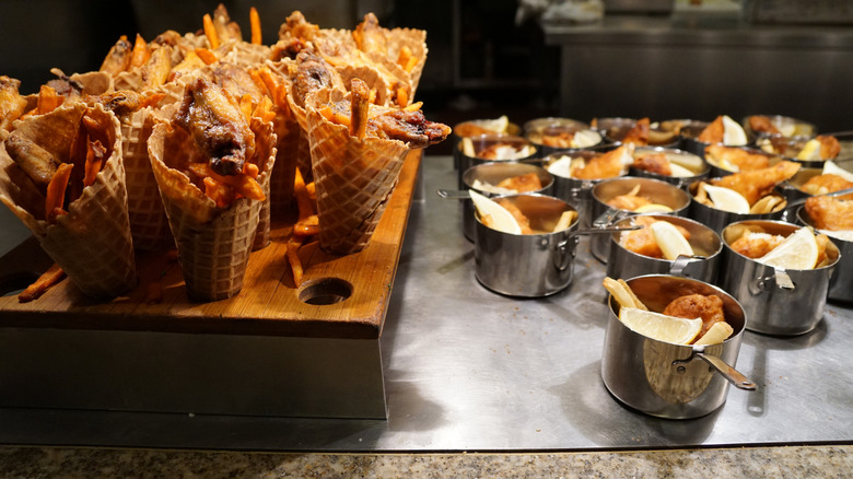 waffle cones with fries and small pots of food at a buffet