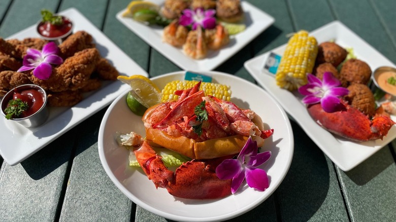 plates of seafood on a picnic table garnished with flowers