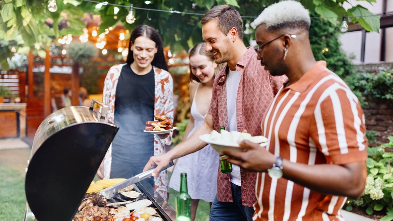 friends standing by grill