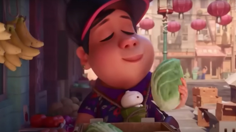 woman holding lettuce at market with baby