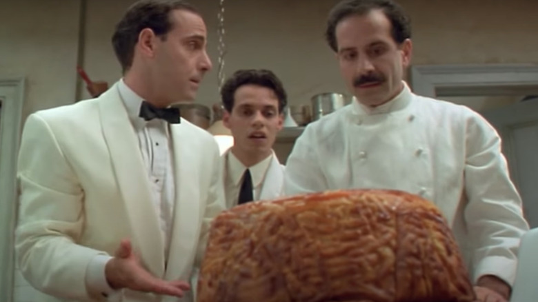 Two men standing in front of giant dome of pasta
