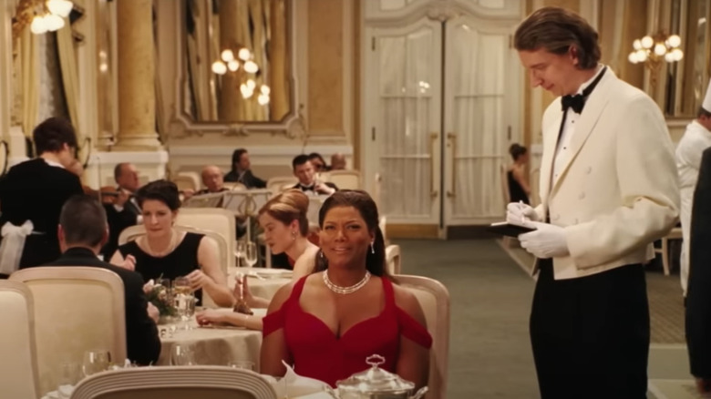 Queen Latifah sitting at a table in a fancy restaurant