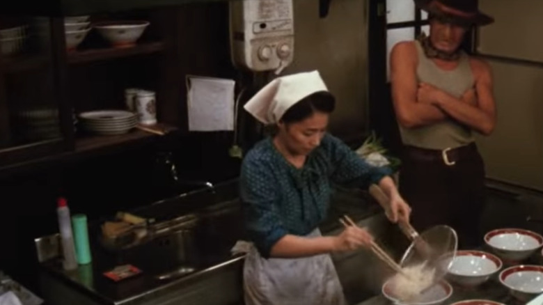 Woman serving noodles into bowls in movie Tampopo
