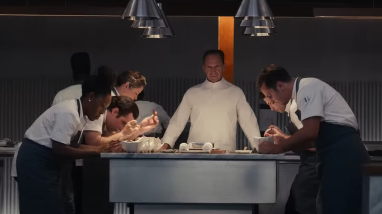 Ralph Fiennes watching over sous chefs in the movie The Menu
