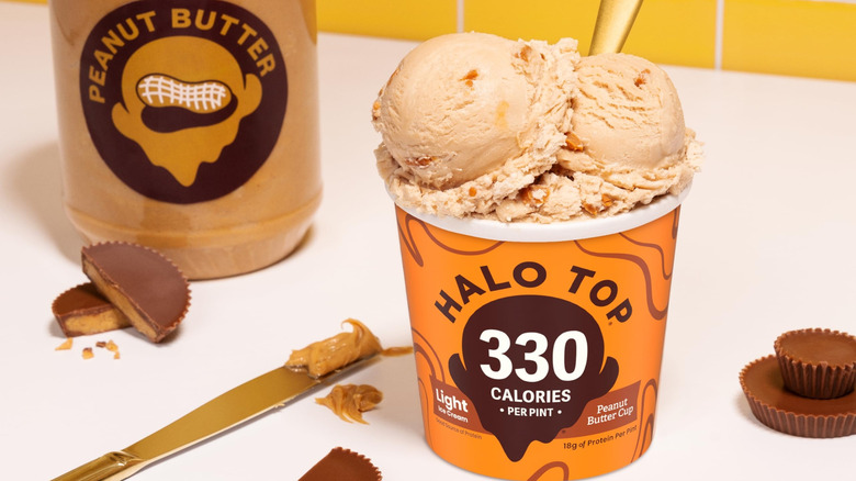 Pint of Halo Top Peanut Butter Cup ice cream next to jar of peanut butter