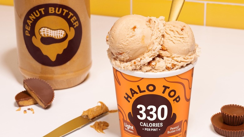 Pint of Halo Top Peanut Butter Cup ice cream next to jar of peanut butter