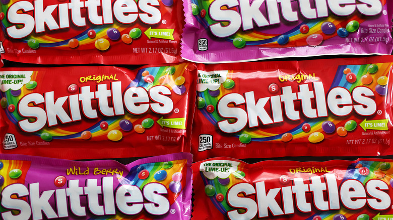 Six packages of orignial flavor and Wild Berry Skittles in two rows of three, close together