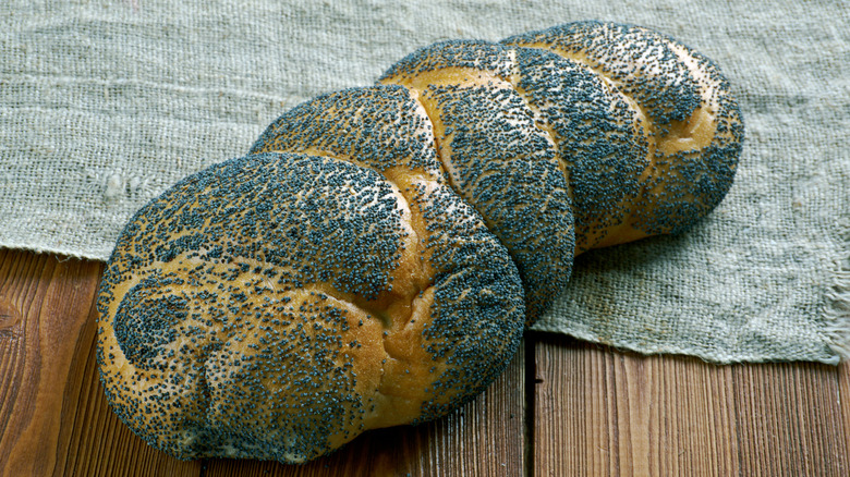 a loaf of Scali bread, topped with poppy seeds, on a table