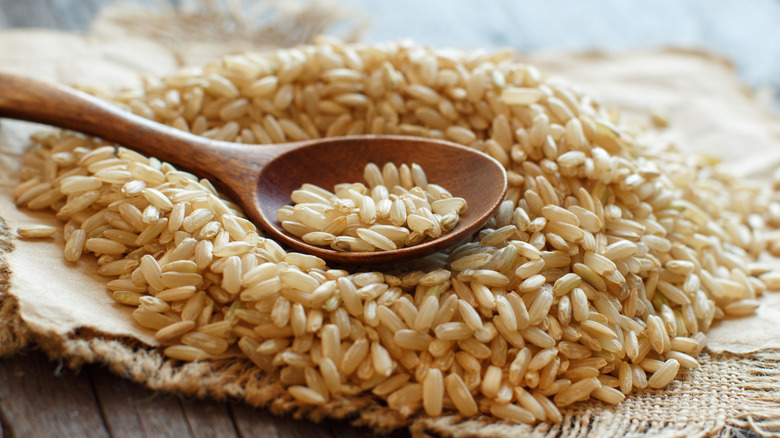 Pile of brown rice with a wooden spoon