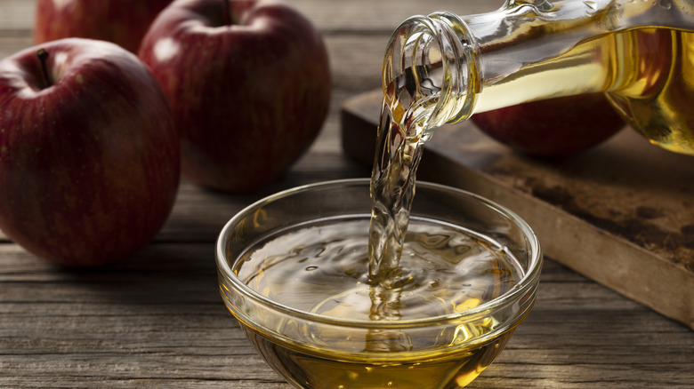 Apple cider vinegar being poured from a bottle