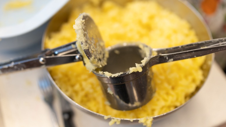 potato ricer over pot of potatoes