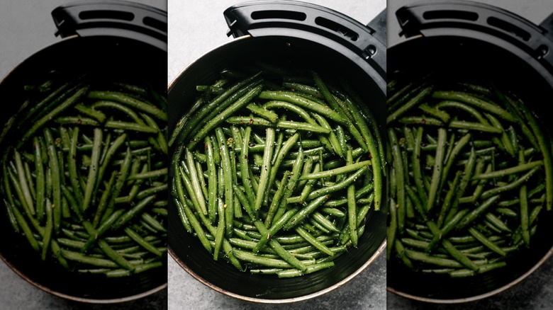 green beans sitting in an air fryer basket