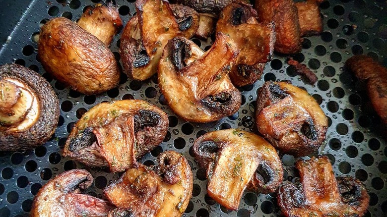 Close-up of cooked mushrooms in an air fryer basket