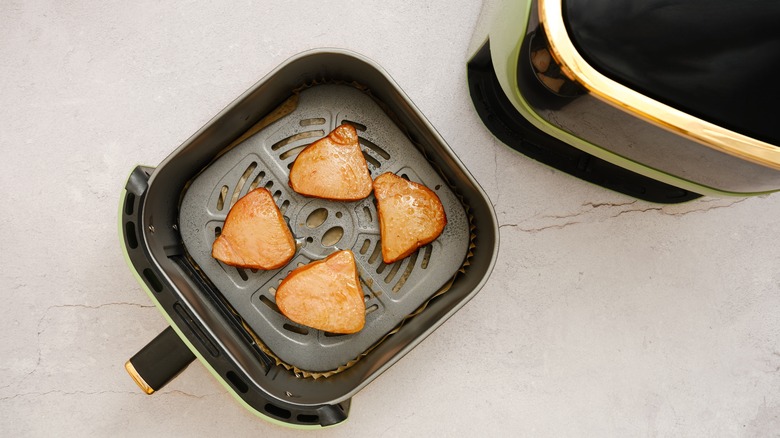 Tuna steaks in an air fryer basket before being cooked
