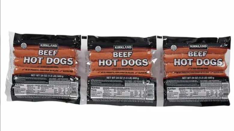 Three packs of Kirkland Signature Hot Dogs on a white background