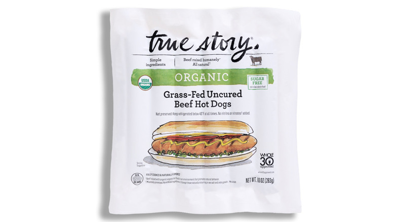 A packet of True Story Organic Grass-Fed Uncured Beef Hot Dogs on a white background