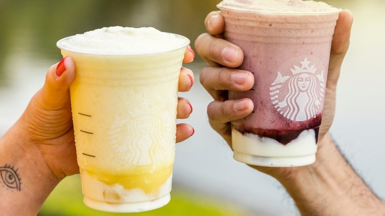 Two hands toasting with Starbucks Frappuccinos