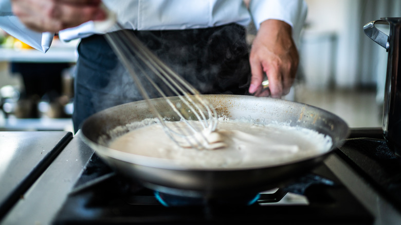 Close-up of a chef preparing a béchamel sauce