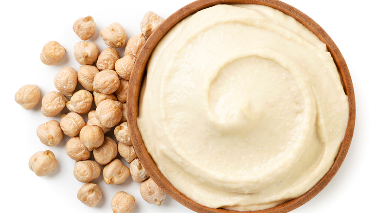 Hummus in a plate and chickpeas close-up on a white background