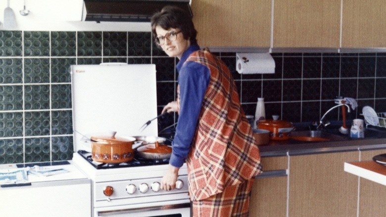 woman cooks food in 1970s kitchen