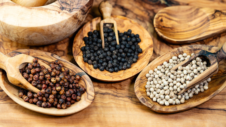 Wooden bowls of red, black and white Kampot peppercorns