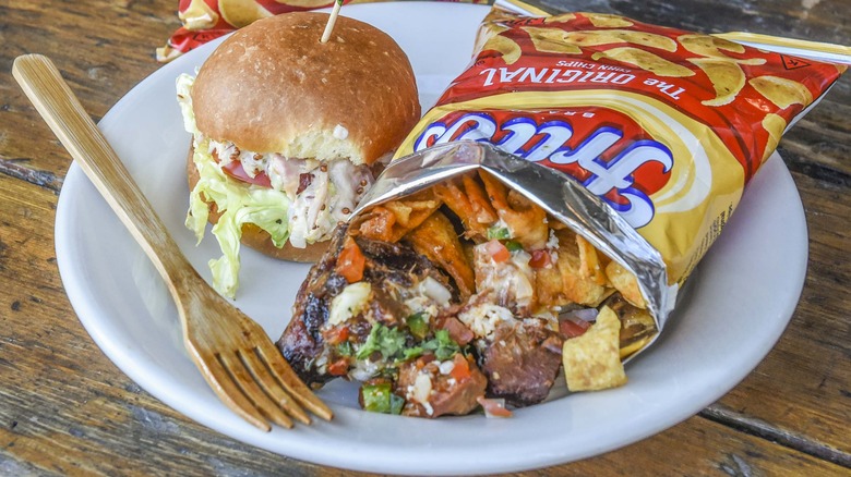 A serving of Frito pie on a white plate