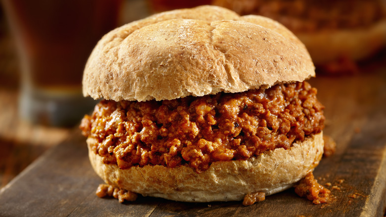 A sloppy joe on a wooden chopping board