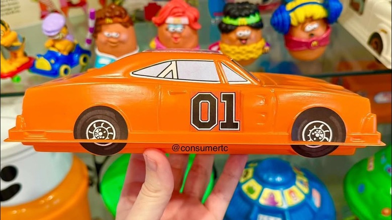 A hand holding a Dukes of Hazzard Happy Meal container