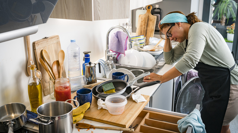 woman overwhelmed by messy kitchen