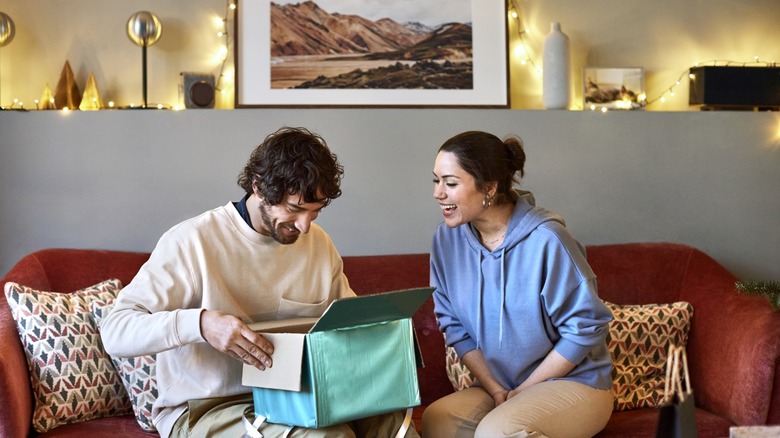 man and woman open presents