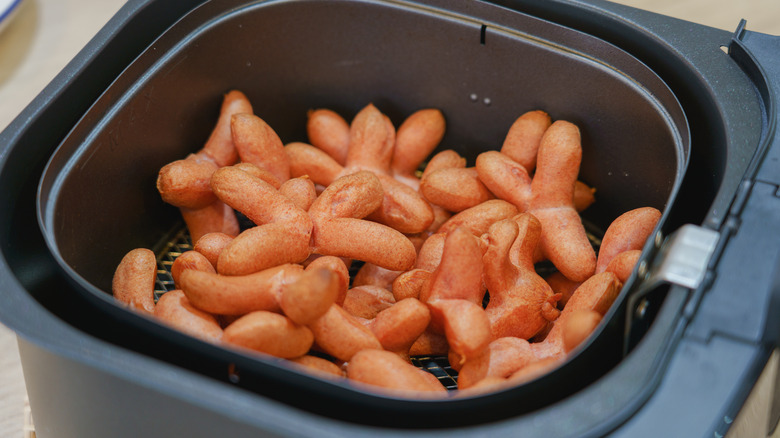 hot dogs sitting inside an air fryer basket