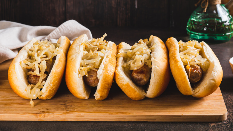 Four hot dogs topped with caramelized onions