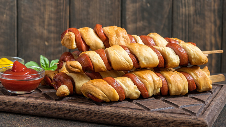 Skewers of spiral-cut hot dog sausages wrapped in pastry