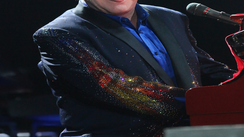 Elton John smiling and sticking his tongue out