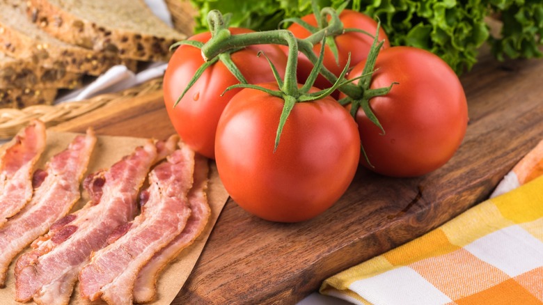 bacon, lettuce, and tomatoes on a wooden board